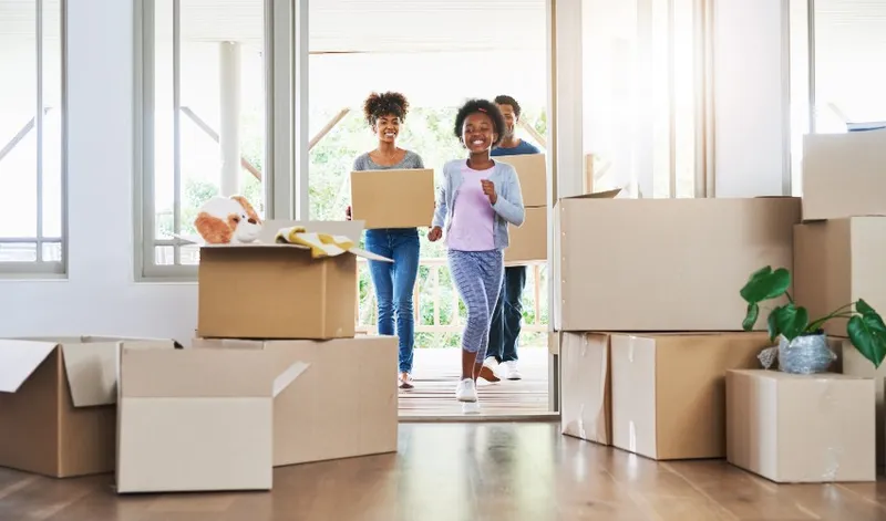 Sản phẩm blog img happy family carrying boxes into their new home — Công Ty TNHH Thế Chiến — MST 0108068074