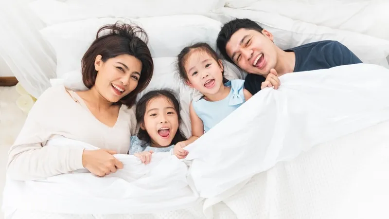 Sản phẩm happy asian family laying on bed — COLGATE-PALMOLIVE - Công Ty TNHH COLGATE-PALMOLIVE (Việt Nam) — MST 0300546015
