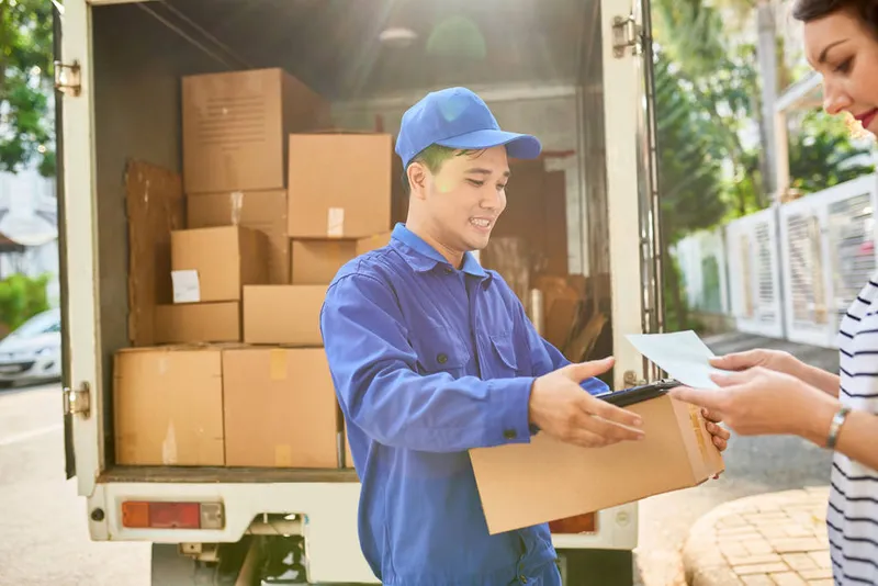Sản phẩm stock photo smiling courier giving document parcel 1 — Công Ty TNHH Vận Tải Và Chuyển Phát Nhanh An Phú — MST 0315638607